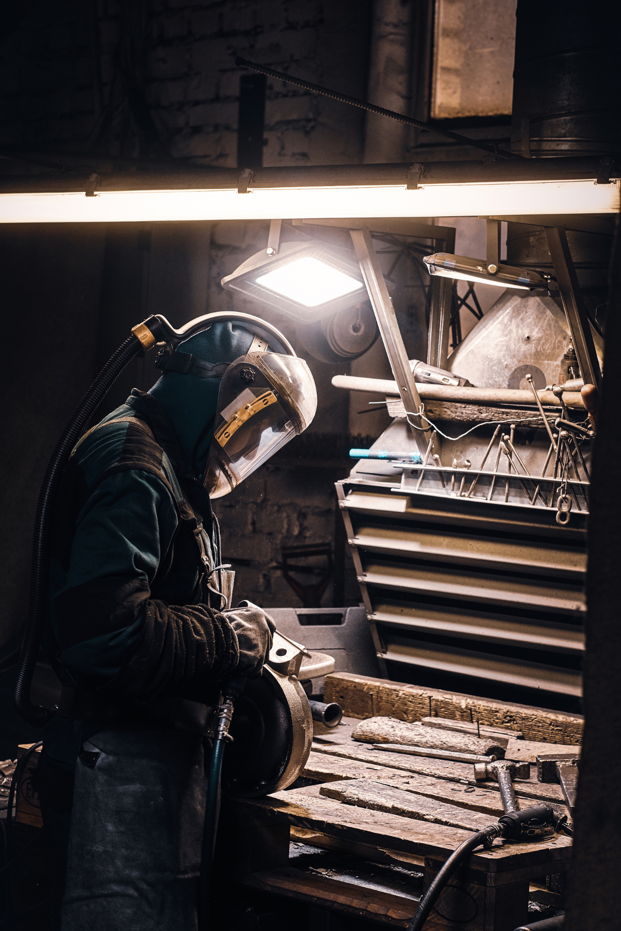 Portrait du métallier artisan dans son atelier, marteau à la main