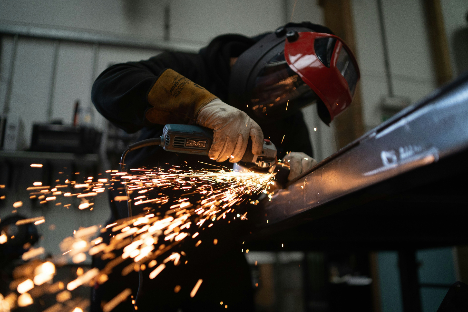Forgeron travaillant l'acier rougi à l'enclume, étincelles dans l'atelier
